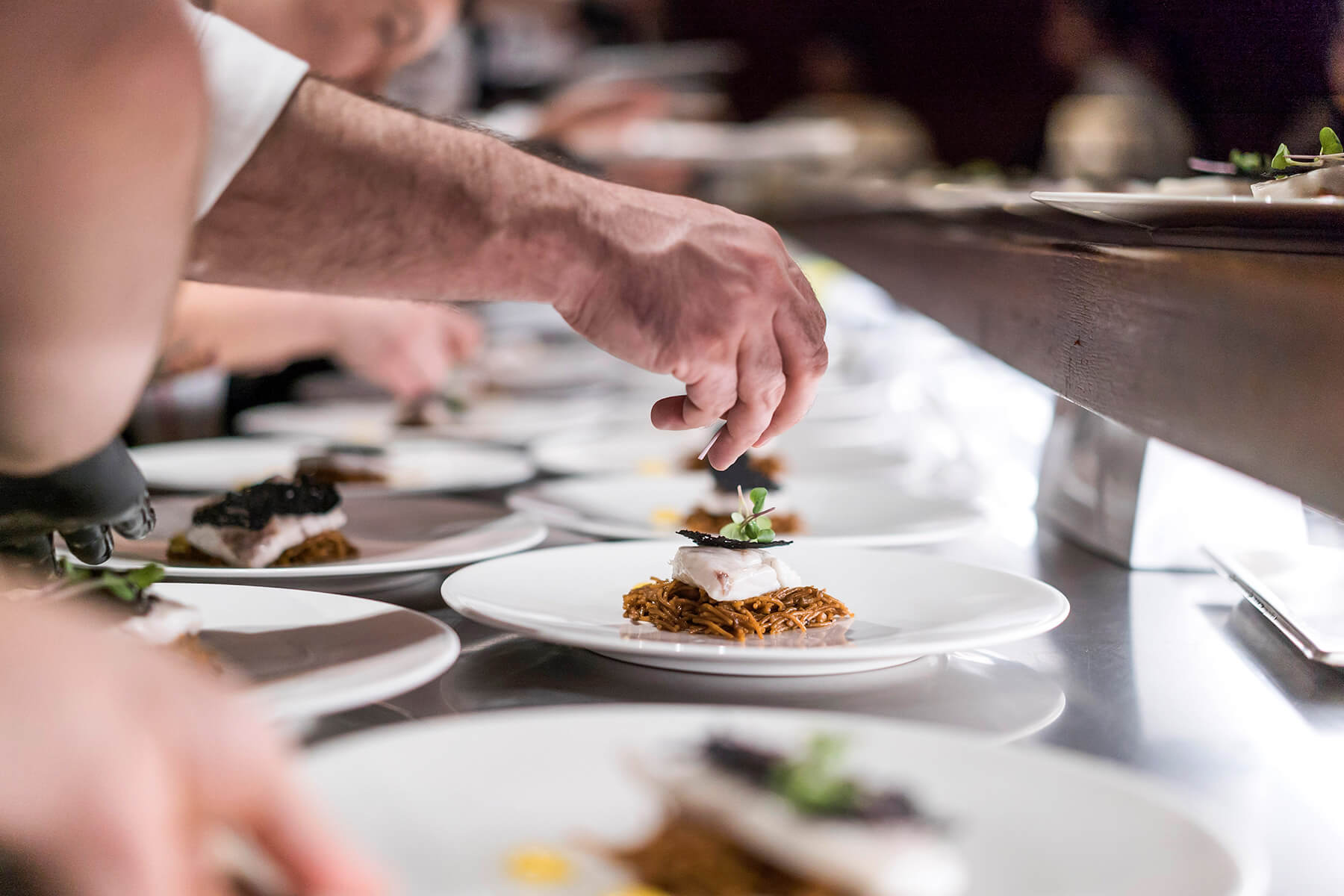 Image of someone adding a garnish to a dish